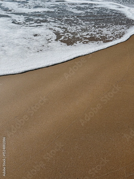 Fototapeta Gentle Waves Lapping on Sandy Beach