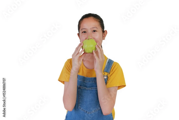 Obraz Portrait of Asian girl holding a fresh guava in hand and looking camera isolated on white studio background.