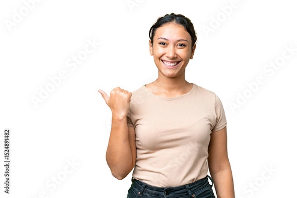 Fototapeta Young Uruguayan woman over isolated chroma key background pointing to the side to present a product