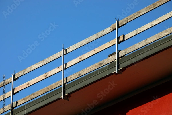 Fototapeta wooden planks of the sturdy protective barrier firmly installed for the safety of workers to prevent falls during maintenance work on the roof of the condominium