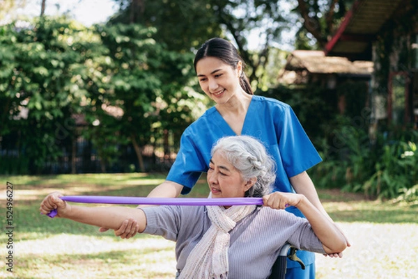Obraz The woman in the wheelchair is holding a purple exercise band