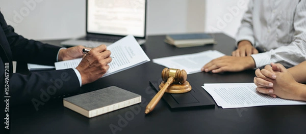Obraz A man is writing on a piece of paper in front of a judge