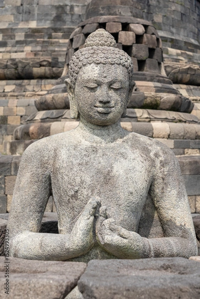 Obraz Closeup front view of ancient Vairocana buddha statue in dharmachakra mudra, Borobudur stupa, Magelang, Central Java, Indonesia