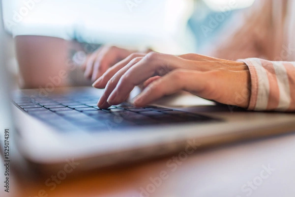 Fototapeta Close up of female finger using laptop trackpad scrolling website for online shopping and browsing. Distance learning.
