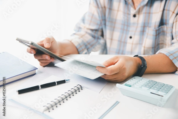 Obraz Business hands holding saving account passbook with calculator, account and saving concept. finance effectively, calculate income, track each bill and payment, accounting for bank statements and tax.