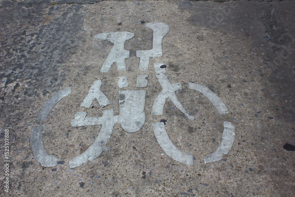 Obraz Bicycle Lane Symbol on Concrete. Faded white bicycle symbol painted on a rough concrete road, designating a bicycle lane.