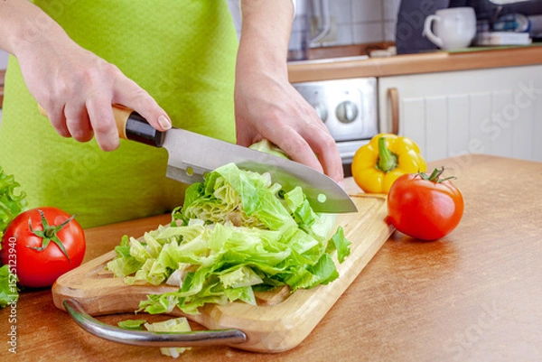 Obraz Woman chopping lettuce on cutting board...