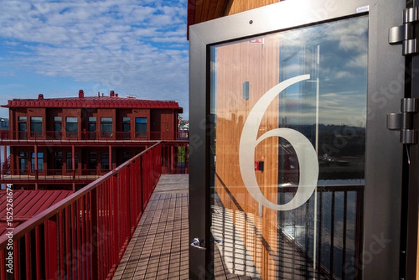 Obraz Number 6 on the glass door of an apartment building, sunny day