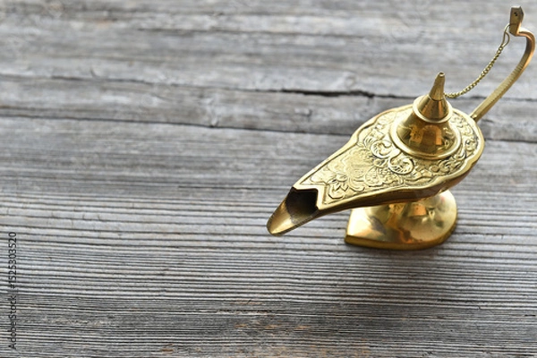 Fototapeta Antique brass genie lamp on rustic wooden table for magical and vintage decor