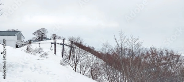 Fototapeta Snow mountains and hills covered with snow in winter under cloudy sky in Japan with unrecognized tourists