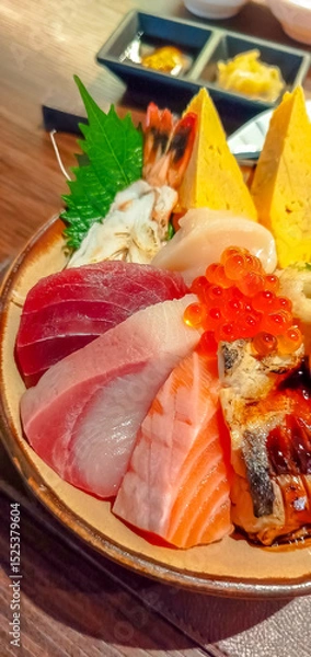 Fototapeta Kaisen don (Rice bowl with sashimi) in Japanese style meal, raw tuna, raw salmon, raw scallop, sweet egg, salmon roe, on sushi sour rice in Japanese restaurant