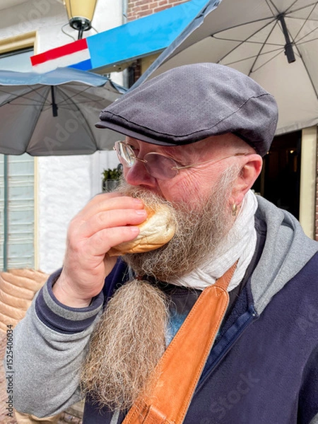 Obraz bärtiger Mann genießt ein Fischbrötchen mit Hering