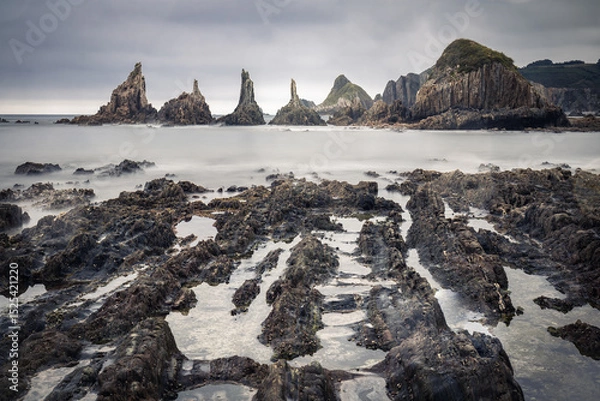Obraz scenic seascape with rising rocks on the beach in long exposure