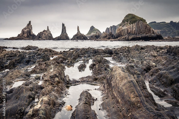 Obraz scenic seascape with rising rocks on the beach in long exposure