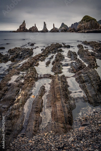 Obraz scenic seascape with rising rocks on the beach in long exposure