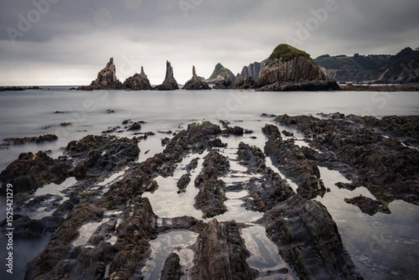 Obraz scenic seascape with rising rocks on the beach in long exposure