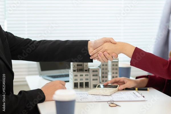 Obraz Inside a real estate office a real estate agent is presenting a condominium unit for sale to a client and offering a valuable promotion to entice the client to purchase their own property. copy space