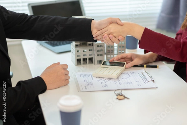 Obraz Inside a real estate office a real estate agent is presenting a condominium unit for sale to a client and offering a valuable promotion to entice the client to purchase their own property. copy space