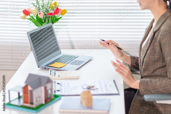 Obraz Inside a real estate office a real estate agent is using a house mockup to present the design and promotions that the client will receive when they sign sales contract. Real estate investment concept