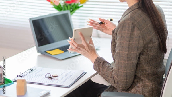 Obraz Inside a real estate office a real estate agent is using a house mockup to present the design and promotions that the client will receive when they sign sales contract. Real estate investment concept
