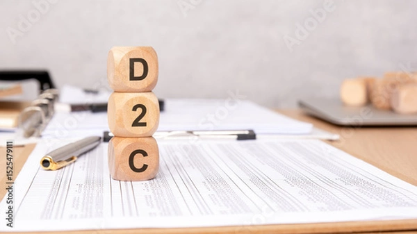 Obraz D2C letters on wooden cubes stacked on office paperwork