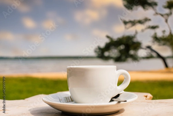 Obraz Cup of coffee or espresso placed on a wooden table facing the sea