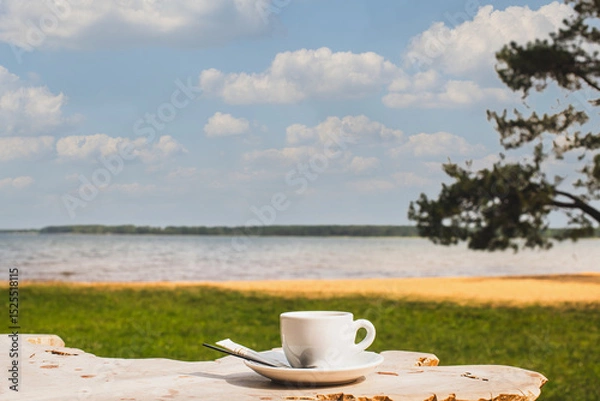 Obraz Cup of coffee or espresso placed on a wooden table facing the sea