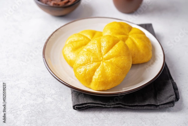 Obraz Pumpkin steamed buns with red bean paste filling in a plate