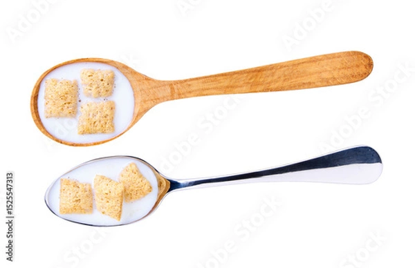 Fototapeta corn pillows with milk in a metal spoon isolated on white background, top view.
