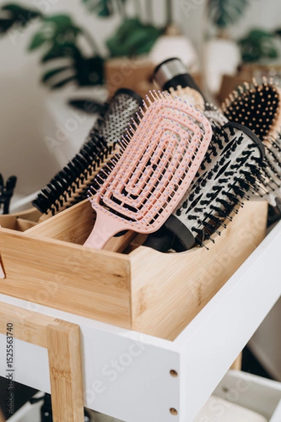 Fototapeta Wicker basket with scalp massage brushes arranged in spa salon head care setting