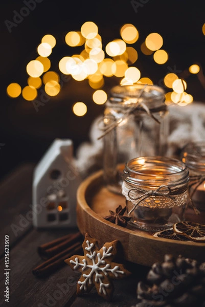 Obraz Aromatic christmas handmade candle with the sweet scent of gingerbread cookies. Cozy holiday home atmosphere, aromatherapy. Interior composition with burning candles, anise, cinnamon, pine cones
