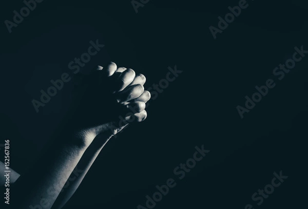 Fototapeta modląca się ręka kobiety w ciemności (modlitwa w koncepcji sekretnego pokoju)