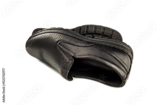 Fototapeta Close-up of elegant black men's shoes on a snow-white background. The photo shows a detailed view of fashionable men's shoes.