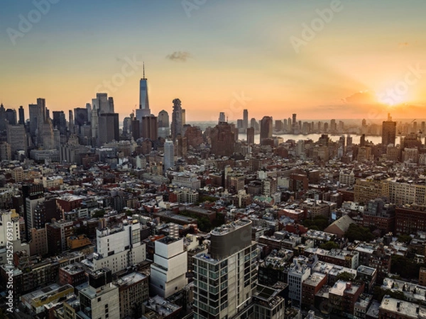 Obraz Sunset above New York Lower Manhattan buildings at summer. Warm Late afternoon light behind the clouds