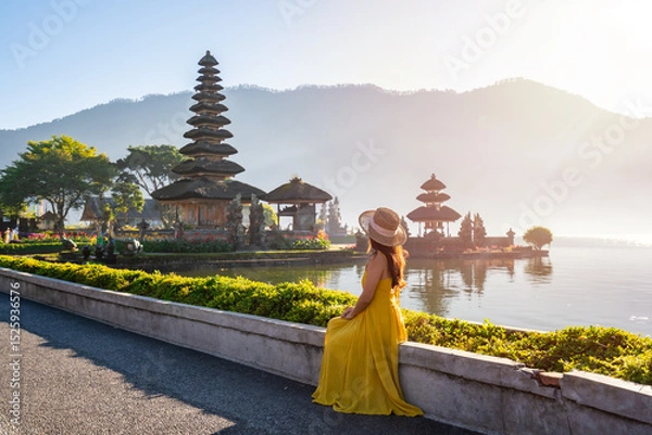 Fototapeta Young woman tourist relaxing and enjoying the beautiful view at Ulun Danu Beratan temple in Bali, Indonesia