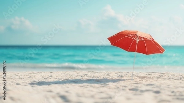 Fototapeta summer concept. Beach scene with a red umbrella and turquoise water in the background.