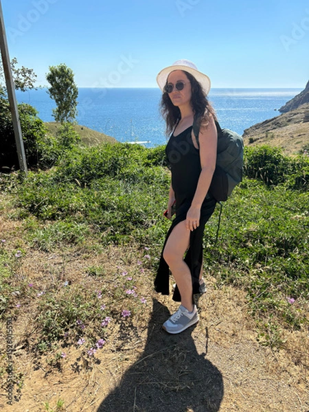 Obraz A girl in a hat walks by the sea