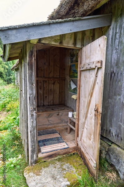Obraz Old outhouse with an open door in the countryside