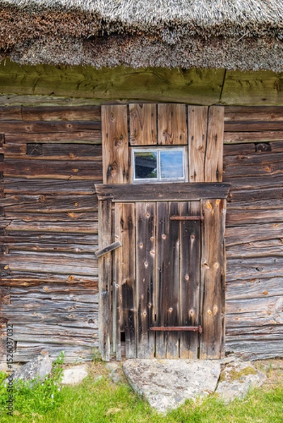 Obraz Door on a agricultural building built with wooden logs