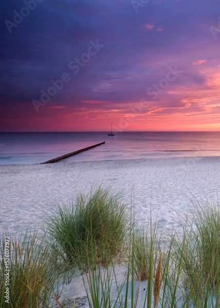Fototapeta amazing colorful Sunset Over Weathered Wooden Groynes at the beach