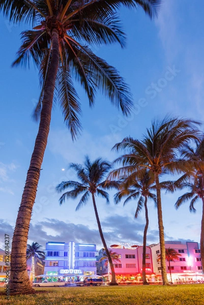 Fototapeta Colorful Art Deco hotels on Ocean Drive in Miami Beach glow under the warm hues of a vibrant sunset