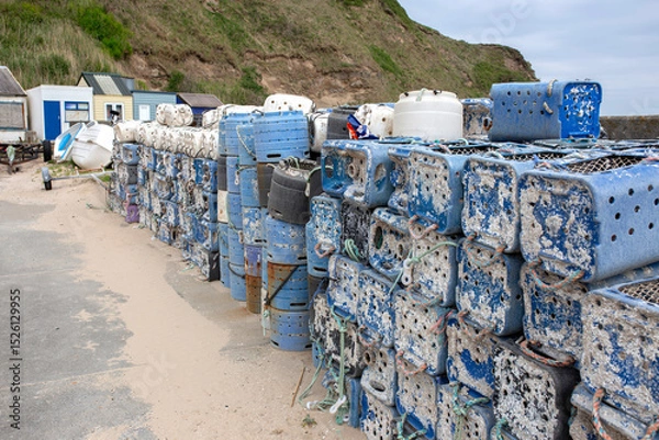 Obraz Lobster and crab commercial fishing pots traps stacked  at a harbour port background backdrop. Made from recycled plastic containers.