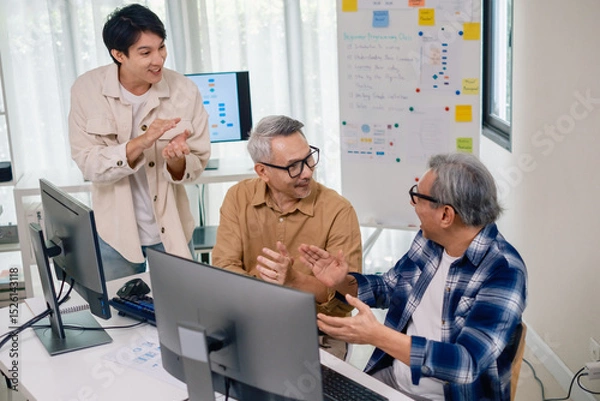 Obraz Senior developer team celebrates success in software collaboration and coding at a modern computer workstation