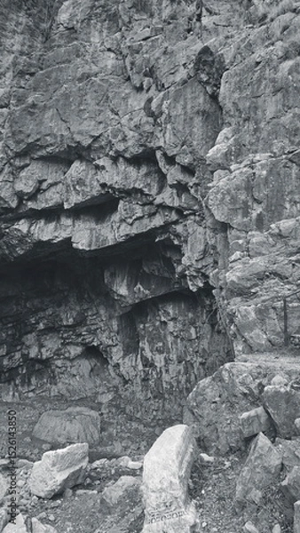 Fototapeta Ancient Stone Cliff With Ruins Monochrome Vertical Texture Closeup Natural Scene Rocky View