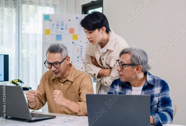Fototapeta Senior developer team celebrates success in software collaboration and coding at a modern computer workstation