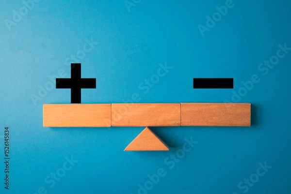 Obraz Wooden blocks forming a balance scale with plus and minus signs on blue background concept for comparison, weighing advantages,decision-making,strategic evaluation,SWOT analysis.