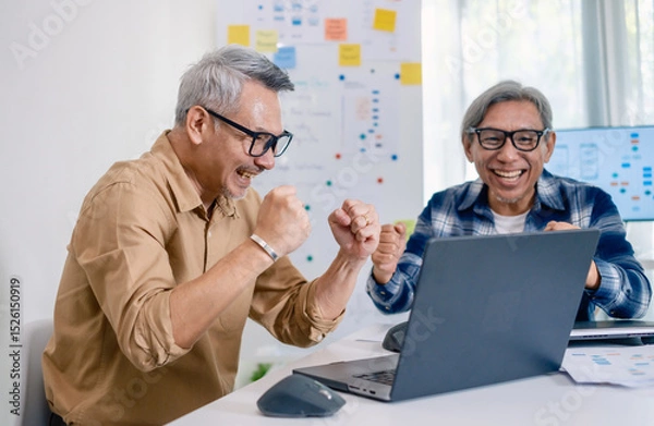 Obraz Senior developer team celebrates success in software collaboration and coding at a modern computer workstation