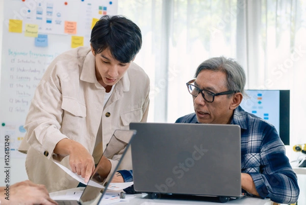 Fototapeta Group of asian senior in a collaborative software development analyzing  flowcharts  during a bootcamp training