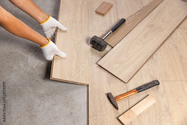 Fototapeta Worker Installing Interlocking laminate floor, home renovation.