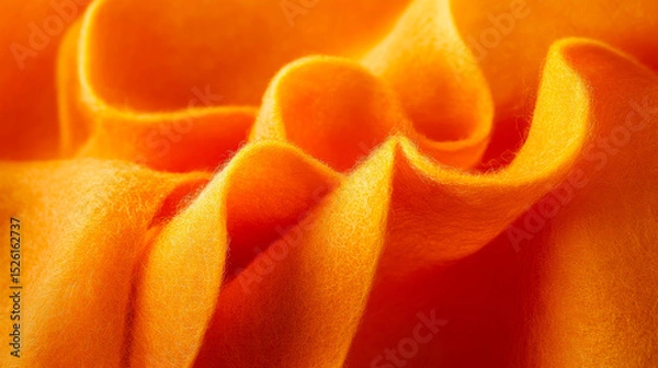 Fototapeta Vibrant orange fabric draping elegantly with soft texture and subtle folds captured in close-up view